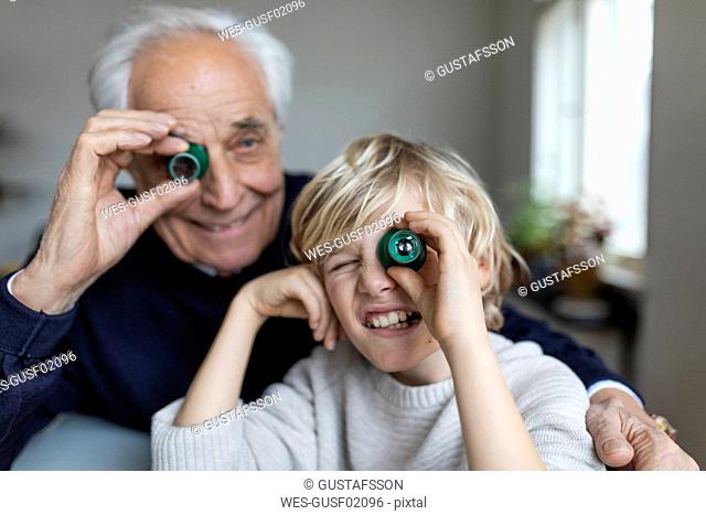 Watchmaker and his grandson looking through oculars