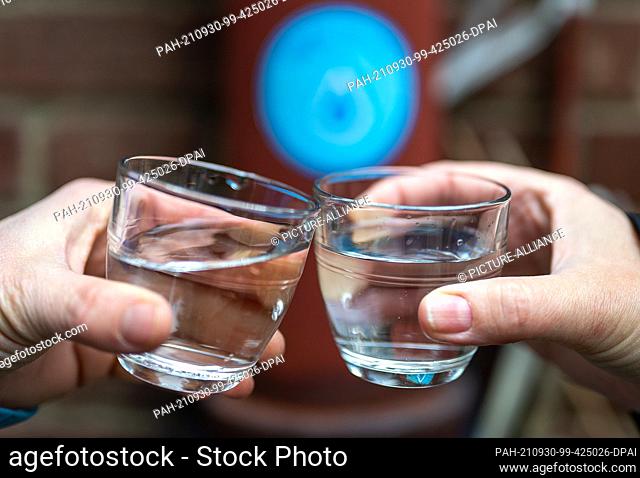 30 September 2021, Berlin: Two people toast with water from a public Refill station at the Reformation Church in Wiclefstraße at a press event before the start...