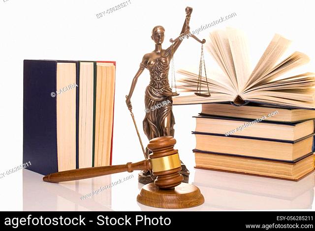statue of justice, judge's hammer behind books on a white background