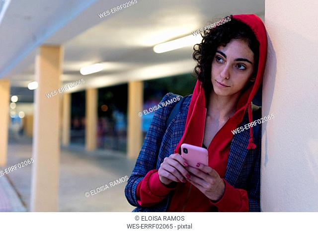Portrait of young woman with mobile phone in the evening