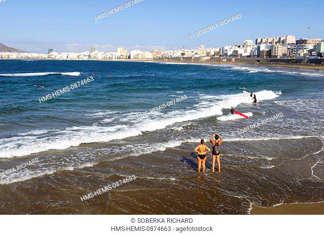 Spain, Canary Islands, Gran Canaria, Las Palmas de Gran Canaria, Las Canteras beach, walkers feet in the water and watching the buildings