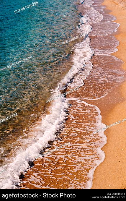 Sea waves on the background of a sandy beach. Side view. High quality photo