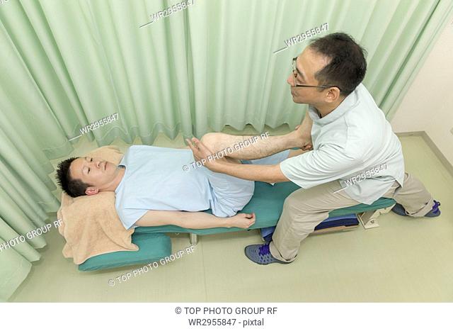 Doctor Manipulating the Legs of A Man