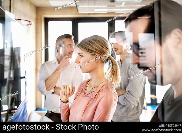 Businesswoman with colleagues having discussion in office