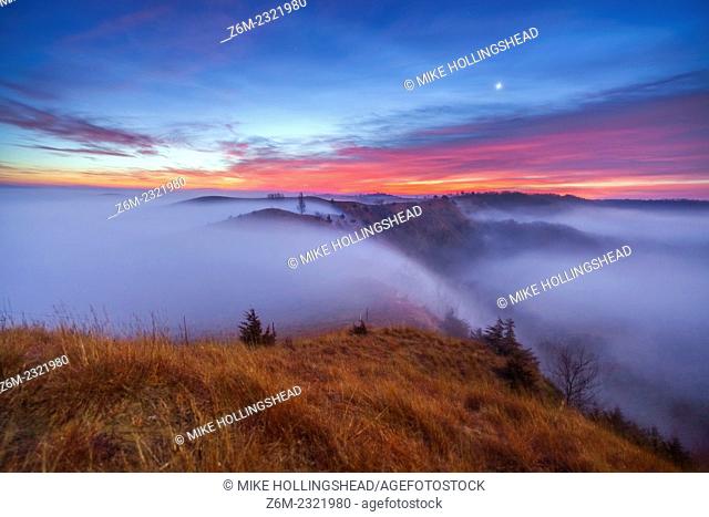 Moonlit fog flows in the valleys around the Loess Hills in western Iowa at sunrise