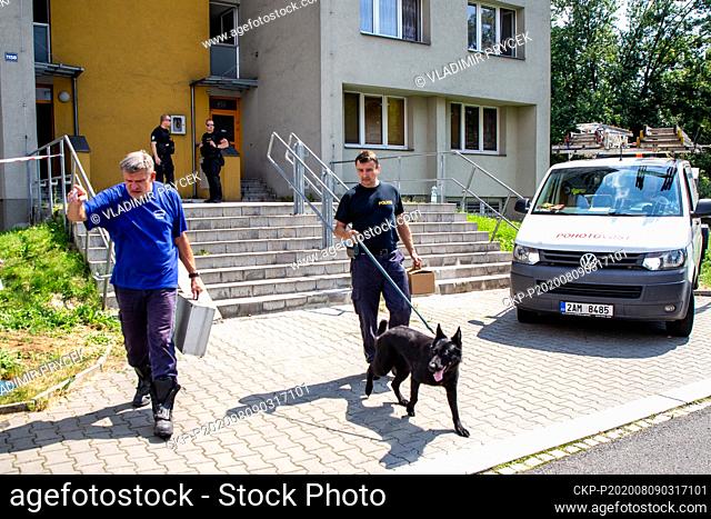 Police technicians with a dog leave the scene one day after arson attack in Bohumin, Czech Republic, on August 9, 2020. Eleven people died in a fire in a...