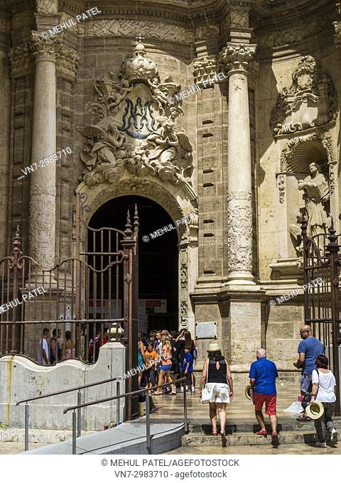 Visitors entering Valencia Cathedral at the Puerta de los Hierros, the main entrance, Cuitat Vella, Valencia, Spain. The Cathedral situated in the Ciutat Vella