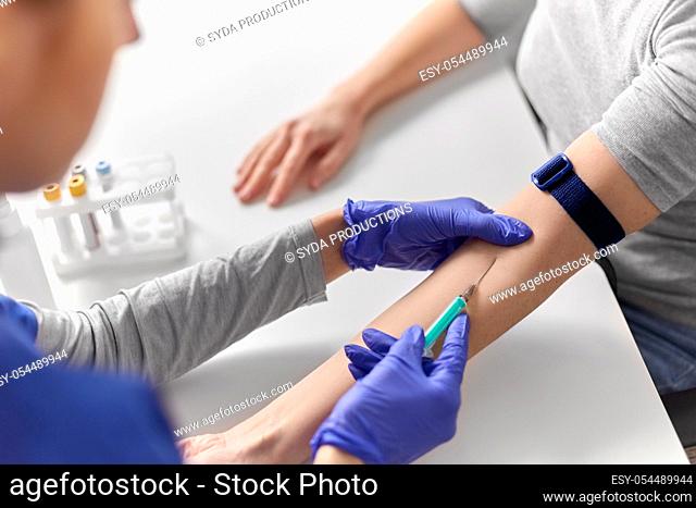 doctor taking blood for test from patient's hand