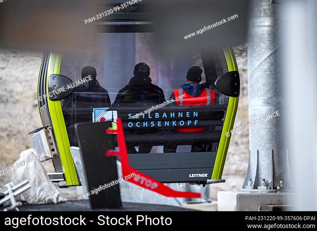 PRODUCTION - 18 December 2023, Bavaria, Bischofsgrün: Three people ride in a gondola of the new 10-passenger single-cable gondola lift from the valley station...