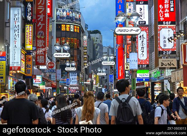 Advertising signs overhanging the streets in the Shibuya shopping district of Tokyo, Japan, Asia