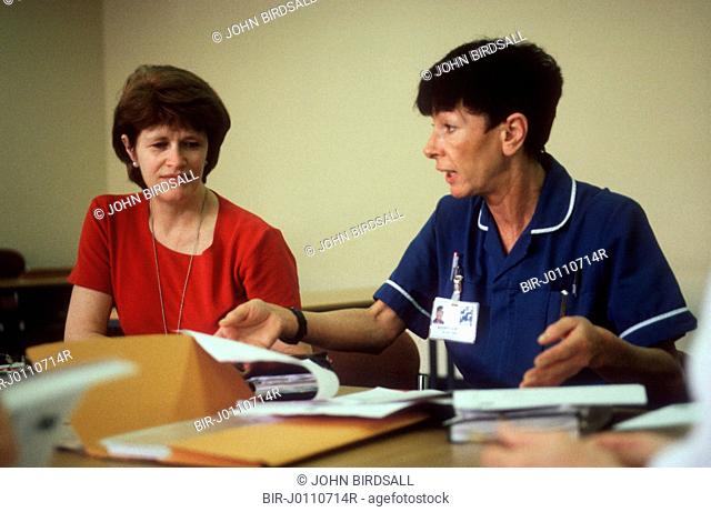 Two health workers sitting around table undergoing staff development training at the Queens Medical Centre, Nottingham