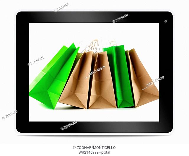 Paper shopping bags on computer tablet screen. Shopping online. E-commerce