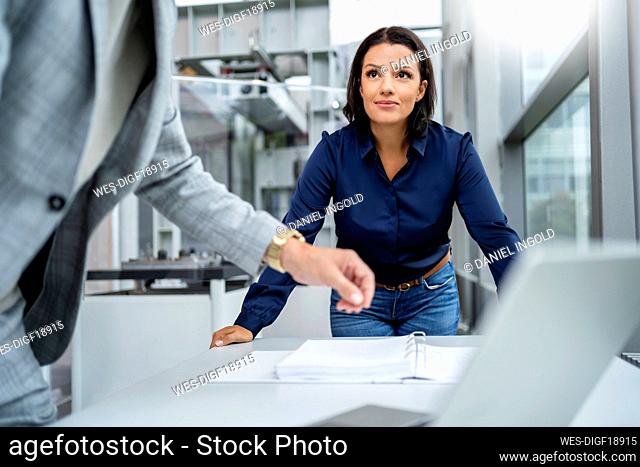Businessman and businesswoman discussing business strategy at desk
