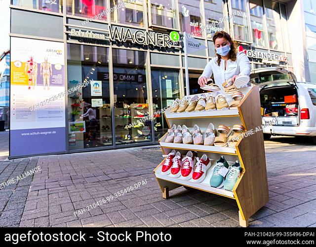 21 April 2021, Rhineland-Palatinate, Bad Kreuznach: Claudia Holbach, Managing Director of ""Schuhhaus Wagner"", equips a display with shoes