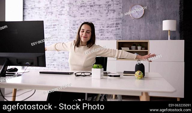 Arms Stretch Exercise Sitting At Desk In Office