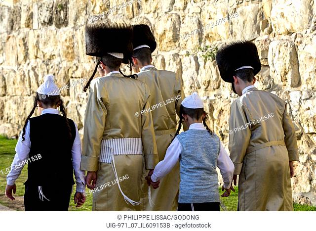 Orthodox jews walking along a wall of Jerusalem old city, Israel