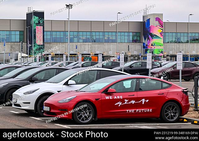 PRODUCTION - 18 December 2023, Brandenburg, Grünheide: Electric vehicles are parked at charging stations in front of the Tesla Gigafactory Berlin-Brandenburg...