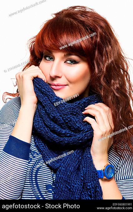 Young beautiful woman with knitted blue wool scarf wrapped around her neck