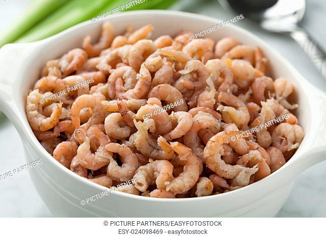 Bowl with peeled brown shrimps close up