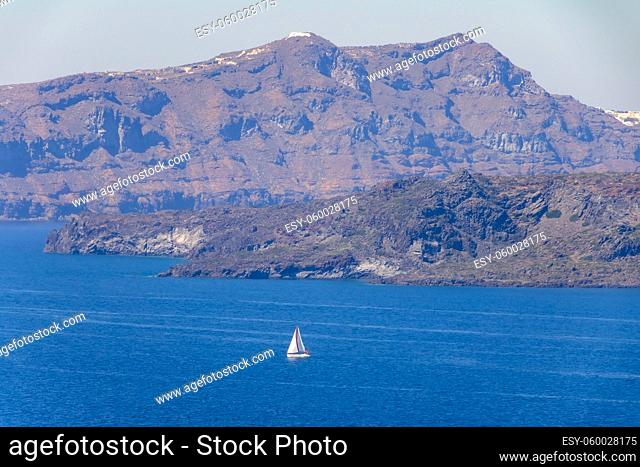 Greece. Rocky coast on a sunny day. White sailing yacht. Aerial view