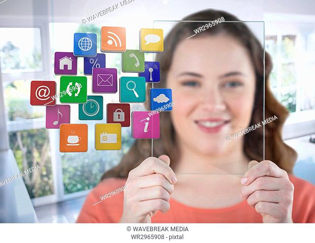 Woman holding glass screen with apps by sunny window