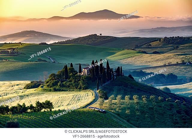 Val d'Orcia, Tuscany, Italy. A lonely farmhouse with cypress and olive trees, rolling hills