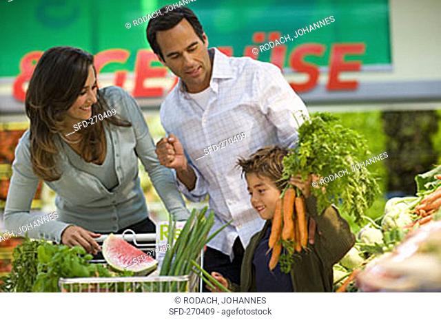 Family at vegetable counter in a supermarket