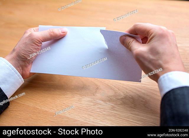 businessman tearing paper by scissors