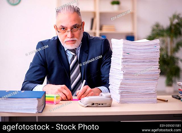 Old male employee unhappy with excessive work at workplace