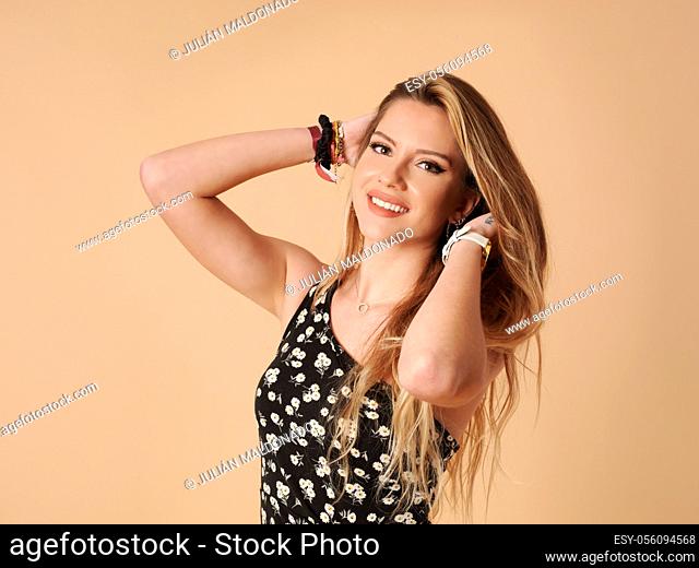 Beautiful young woman with cheerful and friendly fitness holding her hair
