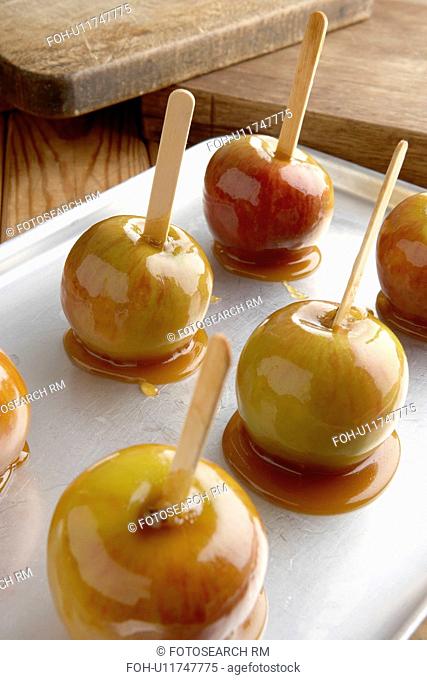 Toffee apples on metal baking tray chopping boards in the background