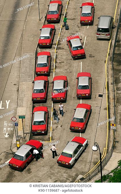 The typical red taxis from Hong Kong seen from above, lining up at a tax stand and waiting for passengers, China, East Asia