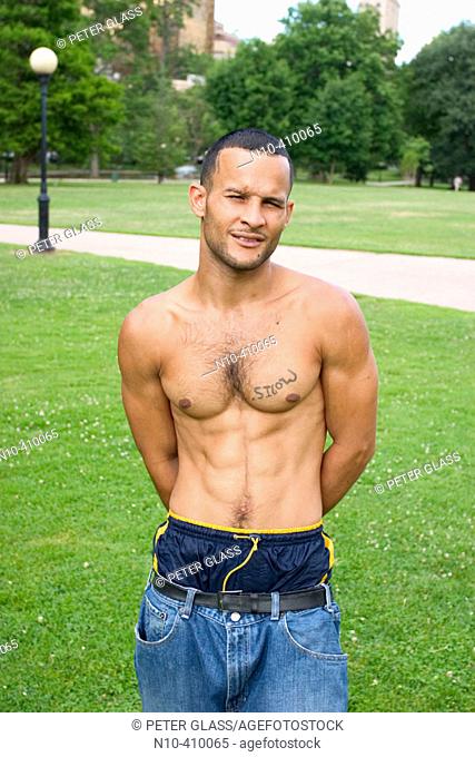 Young shirtless Hispanic man at a park