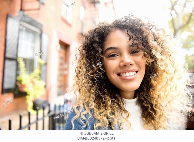 Smiling Mixed Race woman in city
