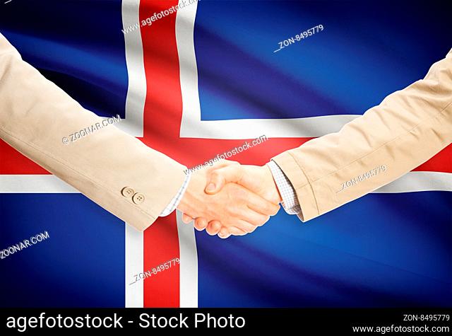 Businessmen shaking hands with flag on background - Iceland