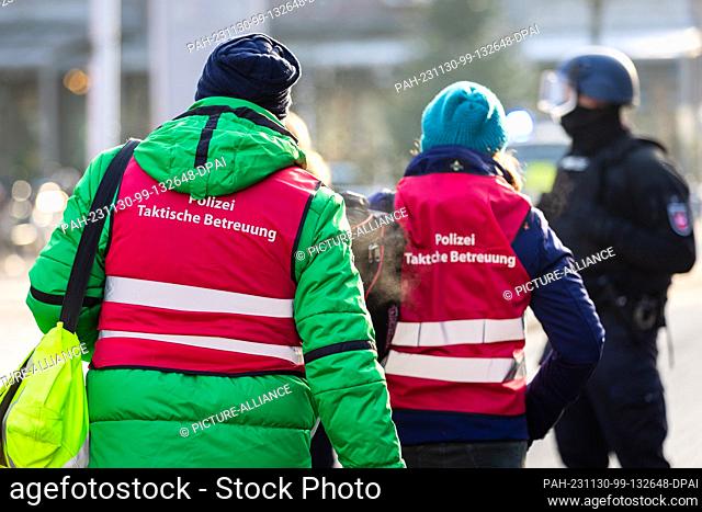 30 November 2023, Lower Saxony, Lehrte: Police tactical support staff walk near a job center. The police have arrested a suspect who is said to have been...