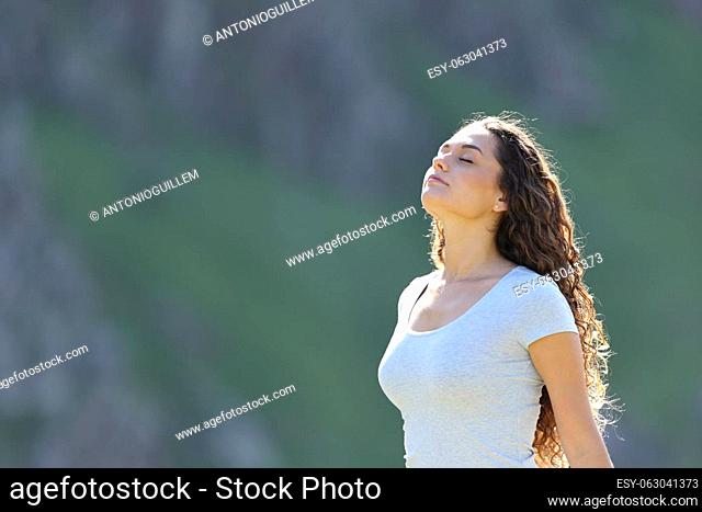 Casual relaxed woman breathing fresh air standing in nature