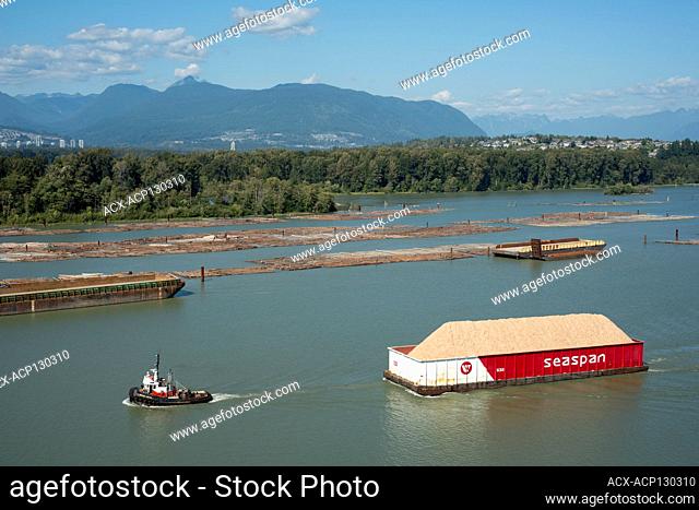Tugboat and wood chip barge in the Fraser River near Surrey, British Columbia, Canada