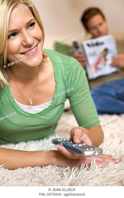 Couple at home with remote control and magazine