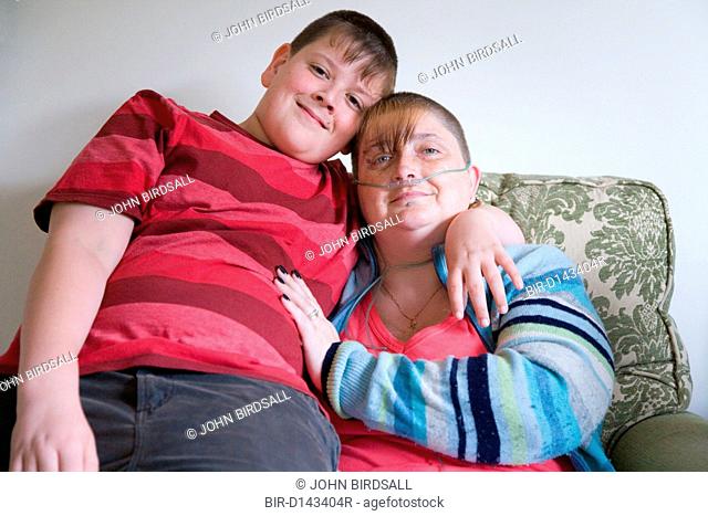 Young carer with his arm around his mum, who is severely asthmatic, who he looks after