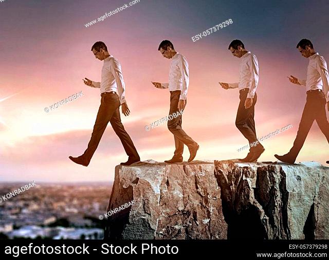 conceptual portrait of a young, successful businessman falling down from the cliff