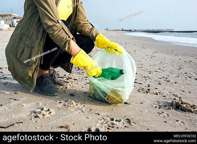 Volunteer picking up waste at beach