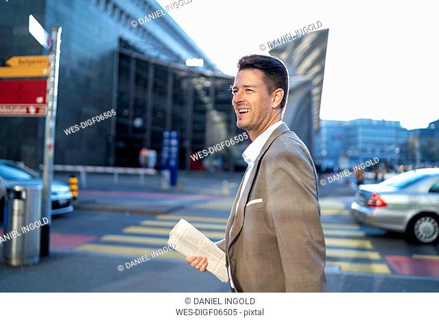 Happy businessman on the move in the city