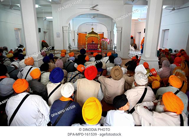 Devotees sitting inside gurudwara and listening to  religious sermons in Anandpur Sahib ; Rupnagar district ; Punjab ; India