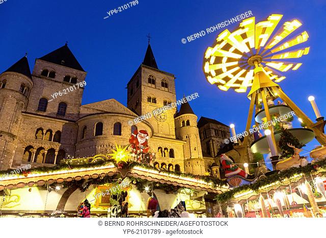 Cathedral of Trier and Christmas market with pyramid at night, Trier, Germany