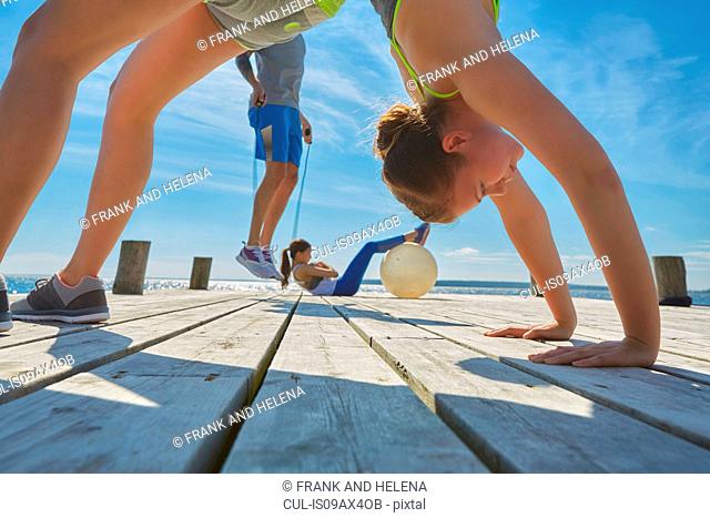 Friends on pier using exercise equipment