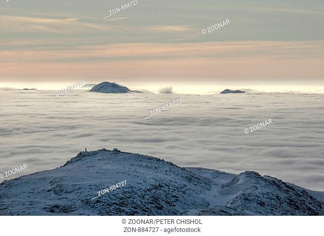 Hillwalker on Ben Challum looking across a cloud inversion to Ben Vorlich