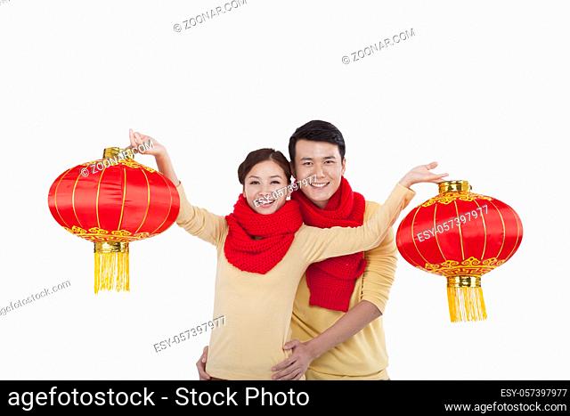 Portrait of young couple holding red lanterns, paying New Year call high quality photo