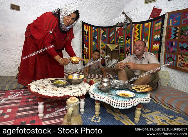 Woman serves meal to visitor troglodyte house Matmata Tunisia