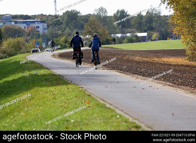 PRODUCTION - 20 October 2022, Mecklenburg-Western Pomerania, Ahrenshoop: Cyclists are on the move on the renovated seawall, northeast of Ahrenshoop